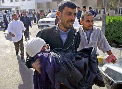 
An Iraqi man carries his child, who was wounded by an  explosion, to a hospital in Baghdad. 
 (Associated Press / The Spokesman-Review)