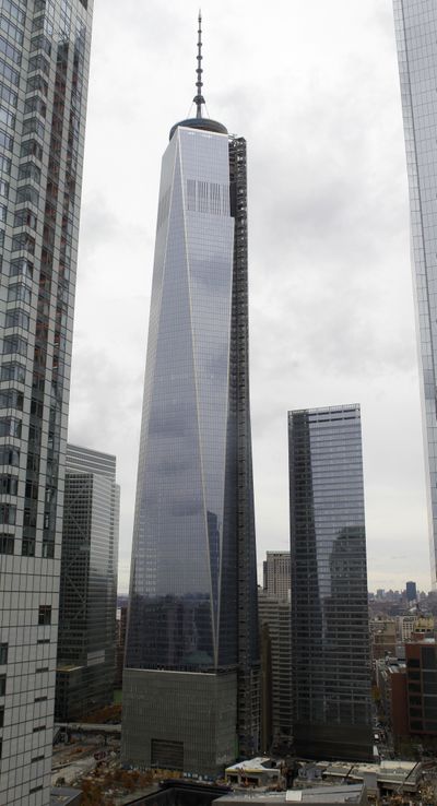 Gray clouds are reflected in the glass facade of One World Trade Center on Tuesday. (Associated Press)