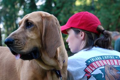 Jenn Gray of Spokane sits in a training session with her 3-year-old bloodhound, Sadie, who will need about two years of training to be field ready for searches. (Rich Landers / The Spokesman-Review)