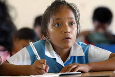 
A young Tuvaluan schoolgirl looks up from her work at her school in Funafuti. 
 (Associated Press photos / The Spokesman-Review)