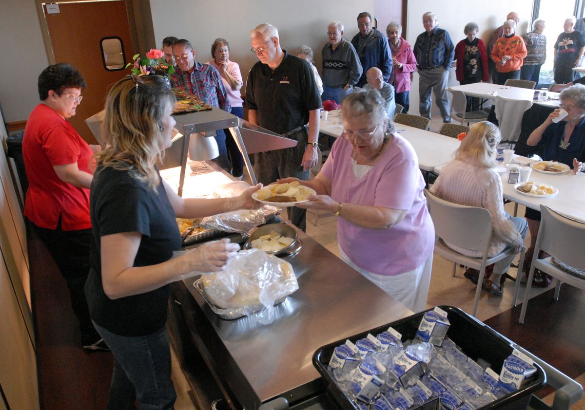 April Lightfoot serves lunch to May Johnson, 79, at the CenterPlace Meals on Wheels luncheon on Tuesday. “People like to come and socialize and have a good hot meal,” said Suzi Walden, a cordinator. (J. Rayniak / The Spokesman-Review)