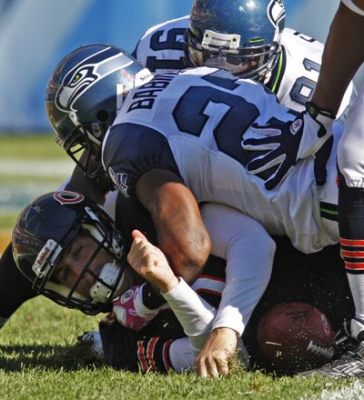 Chicago Bears quarterback Jay Cutler, bottom left, is sacked in the end zone for a safety by Seattle Seahawks defenders Chris Clemons (91) and Jordan Babineaux (27) in the second half of an NFL football game in Chicago, Sunday, Oct. 17, 2010. (Nam Huh / Associated Press)