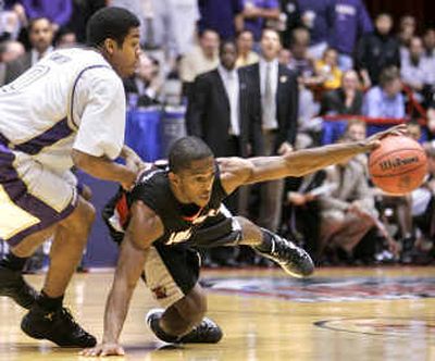 
Washington guard Joel Smith, left, moves in as Louisville's Larry O'Bannon struggles for control of the ball during the second half of their NCAA regional semifinal game.  
 (Associated Press / The Spokesman-Review)