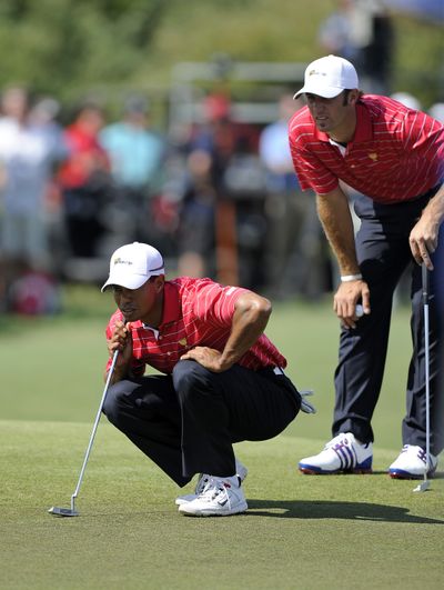 Tiger Woods, left, and Dustin Johnson line up a putt on the first hole during the second round of the Presidents Cup. (Associated Press)