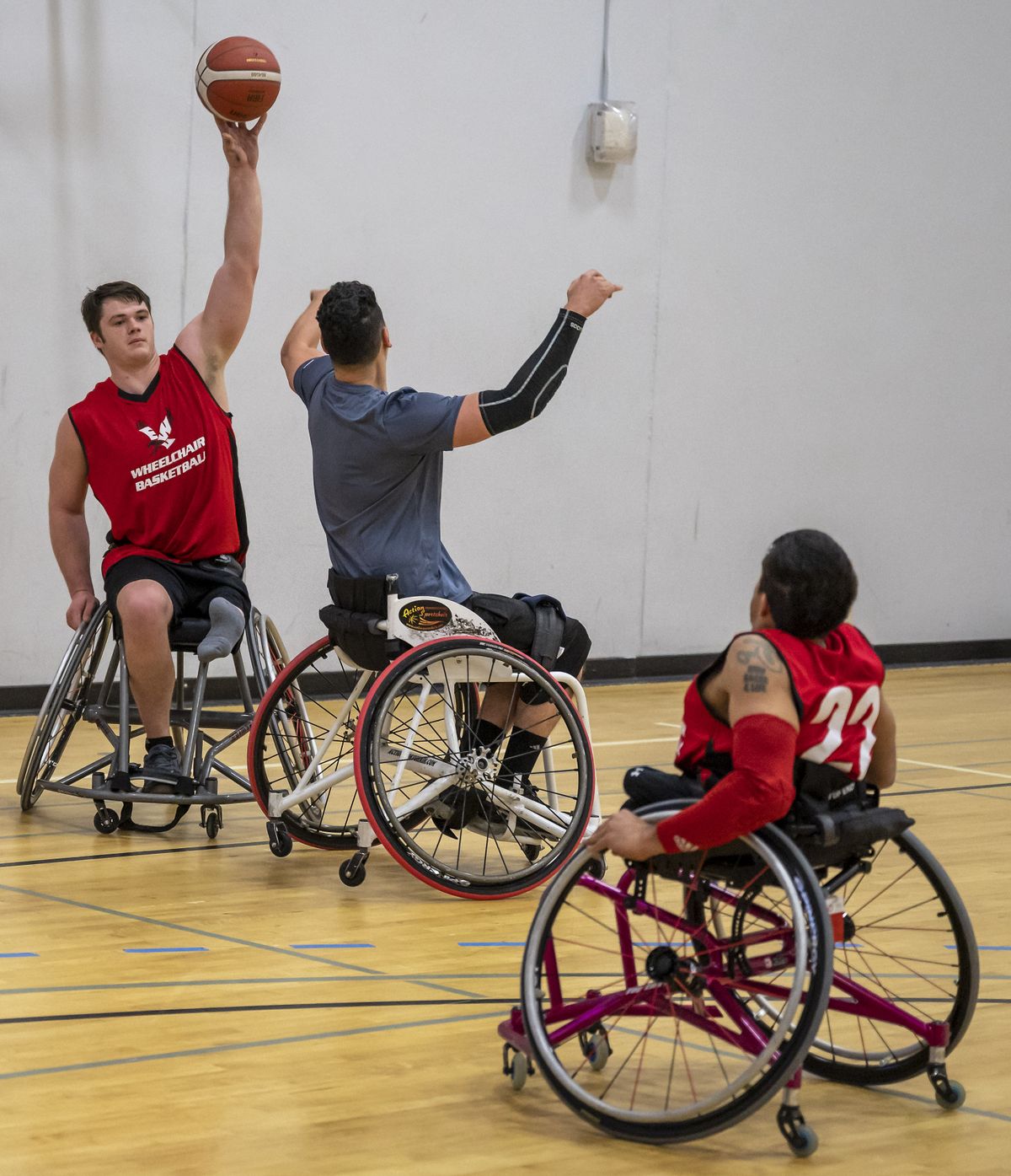 Tyler Hinshaw prepares to pass over coach David Evjen to Bob Hunt during a wheelchair basketball scrimmage at Eastern Washington University on Nov. 20.  (Colin Mulvany/THE SPOKESMAN-REVIEW)