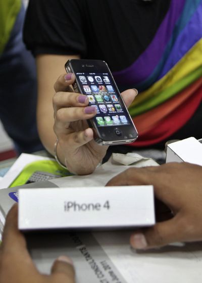 In this May 27, 2011, photo, a salesperson displays an Apple iPhone 4 to a customer in New Delhi. (Associated Press)