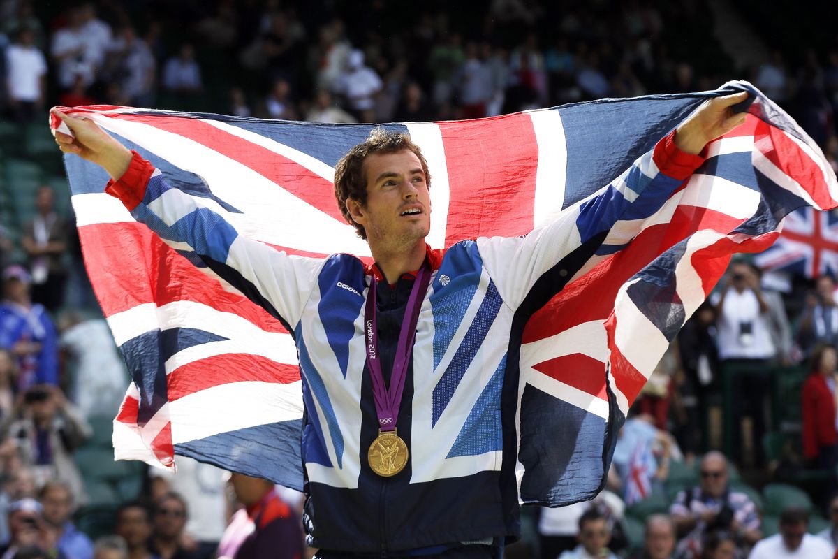 Gold medalist Andy Murray waves the British flag during the medal ceremony of the men’s singles event at the All England Club at Wimbledon, in London, on Sunday. (Associated Press)