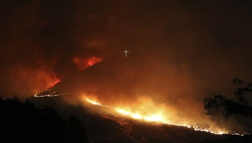 A wildfire burns near the Table Rock cross in Boise, Idaho in the early morning hours of Thursday, June 30, 2016. Strong winds pushed the fire around Table Rock and south toward Warm Springs Mesa subdivision and Harris Ranch, according to the Idaho Statesman. (AP/Idaho Statesman / Joe Jaszewski)