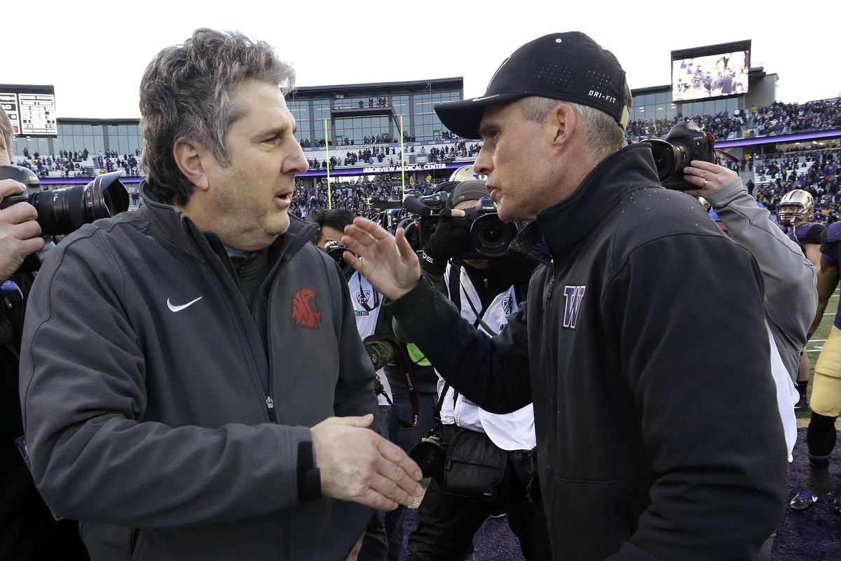 In this Nov. 27, 2015, file photo, Washington State coach Mike Leach, left, is greeted by Washington coach Chris Petersen after an NCAA college football game in Seattle. Rarely have both teams entered the Apple Cup with so much at stake. (Elaine Thompson / AP)