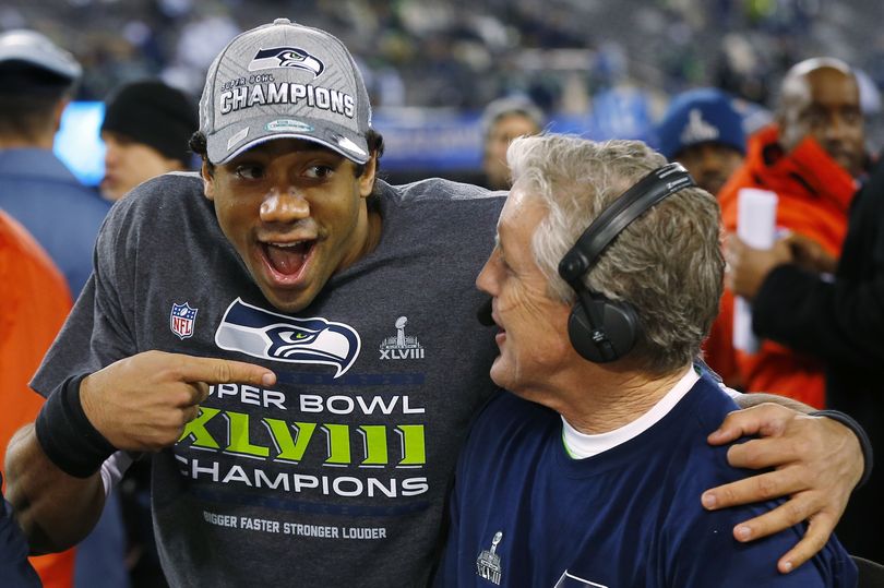 Seahawks quarterback Russell Wilson laughs with head coach Pete Carroll during a television interview after victory. (Associated Press)