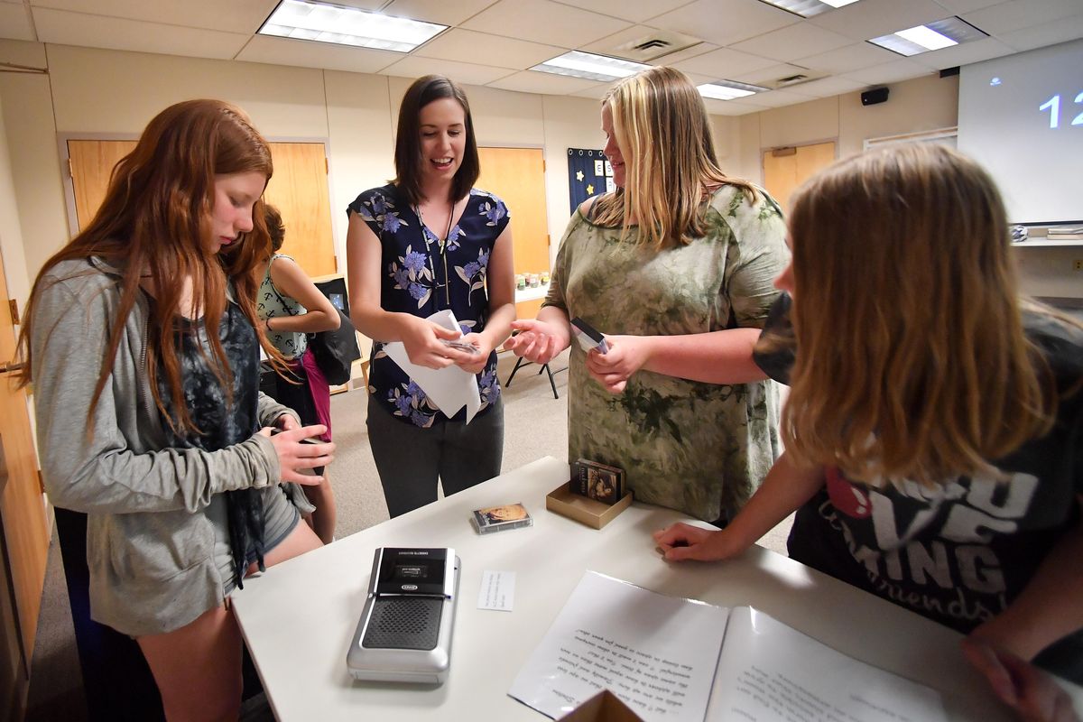 Kaley Graupman, 14, takes pointers from Gina Frerichs, a youth services librarian with Spokane Libraries, on how to use and operate a cassette tape recorder with her friends Betty Perrey, 15, far right, and Madelyn Brown, 14, as the youngsters problem solve their way through an escape room Tuesday, June 25, 2019, at Hillyard Library in Spokane. (Tyler Tjomsland / The Spokesman-Review)