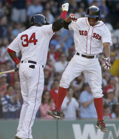 Boston Red Sox’s Xander Bogaerts, right, leaps to celebrate with on-deck batter David Ortiz after hitting a home run during the fifth inning Saturday against the Seattle Mariners. (Mary Schwalm / Associated Press)