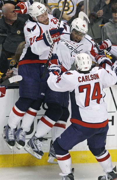 Washington right wing Joel Ward, center, is congratulated by teammates after his winning overtime goal against Boston. (Associated Press)