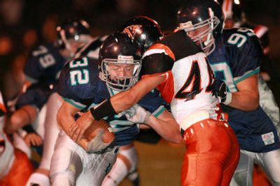 
 Lake City's B.J. Palmer runs through a Kennewick defender during the first half Friday night in Coeur d'Alene. 
 (Cory Murdock / The Spokesman-Review)