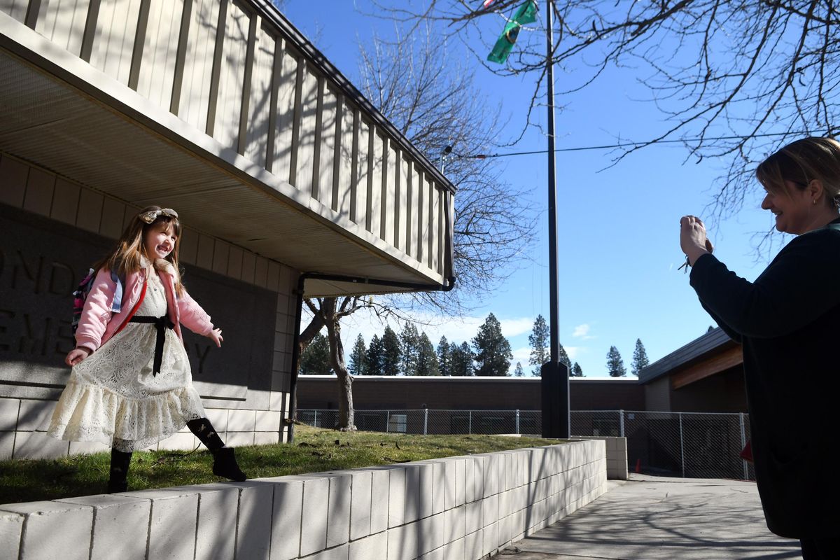 "This school will be demolished soon," said Julia Kushnerchuk as she photographed her daughter Katelyn in front of Ponderosa Elementary in Spokane Valley on Tuesday, March 20, 2018. The new elementary has been built right next door. (Kathy Plonka / The Spokesman-Review)