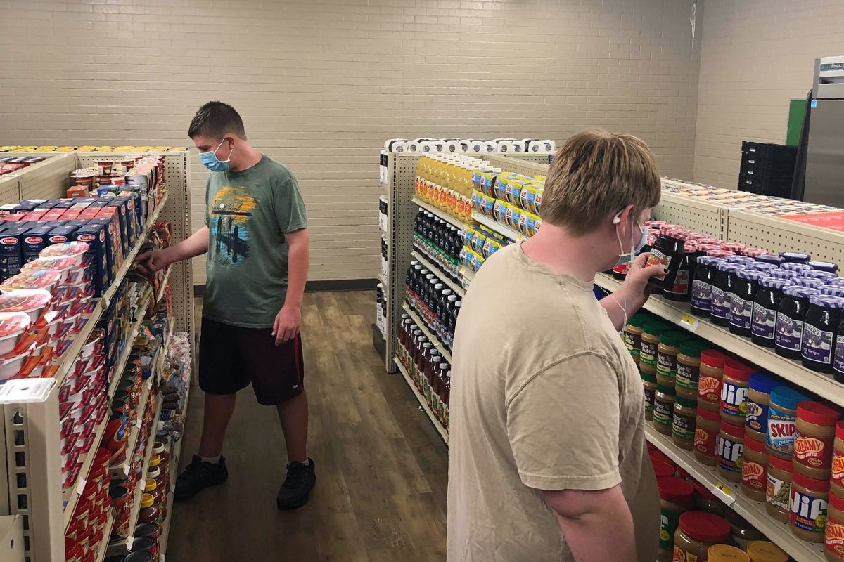 Student Hunter Weertman, 16, left, stocks shelves and takes inventory while working as a manager of the student-led free grocery store at Linda Tutt High School on Nov. 20 in Sanger, Texas. The store provides food, toiletries and household items to students, faculty and community members in need.  (Anthony Love)