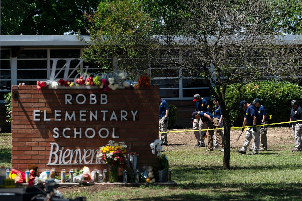 FILE - Investigators search for evidences outside Robb Elementary School in Uvalde, Texas, May 25, 2022, after an 18-year-old gunman killed 19 students and two teachers. Uvalde Consolidated Independent School District Police Chief Pete Arredondo, who served as on-site commander during the shooting, said that he