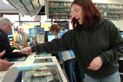 
Liz Thorne, who works at the Seltice Way Stop-N-Go in Stateline, Idaho, takes money and passes out Powerball lottery tickets at a furious pace Friday. The jackpot reached $365 million for tonight's drawing. 
 (Jesse Tinsley / The Spokesman-Review)