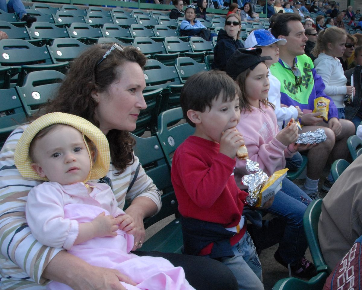 Gemi Nardini, 4, in the red shirt, works on his hot dog during a BlueClaws game as his mom Kirsten, left, holds his sister Talianna. To Gemi’s right are sisters Ellianna and Gianna and father Albert. (Cbh Cbh / The Spokesman-Review)