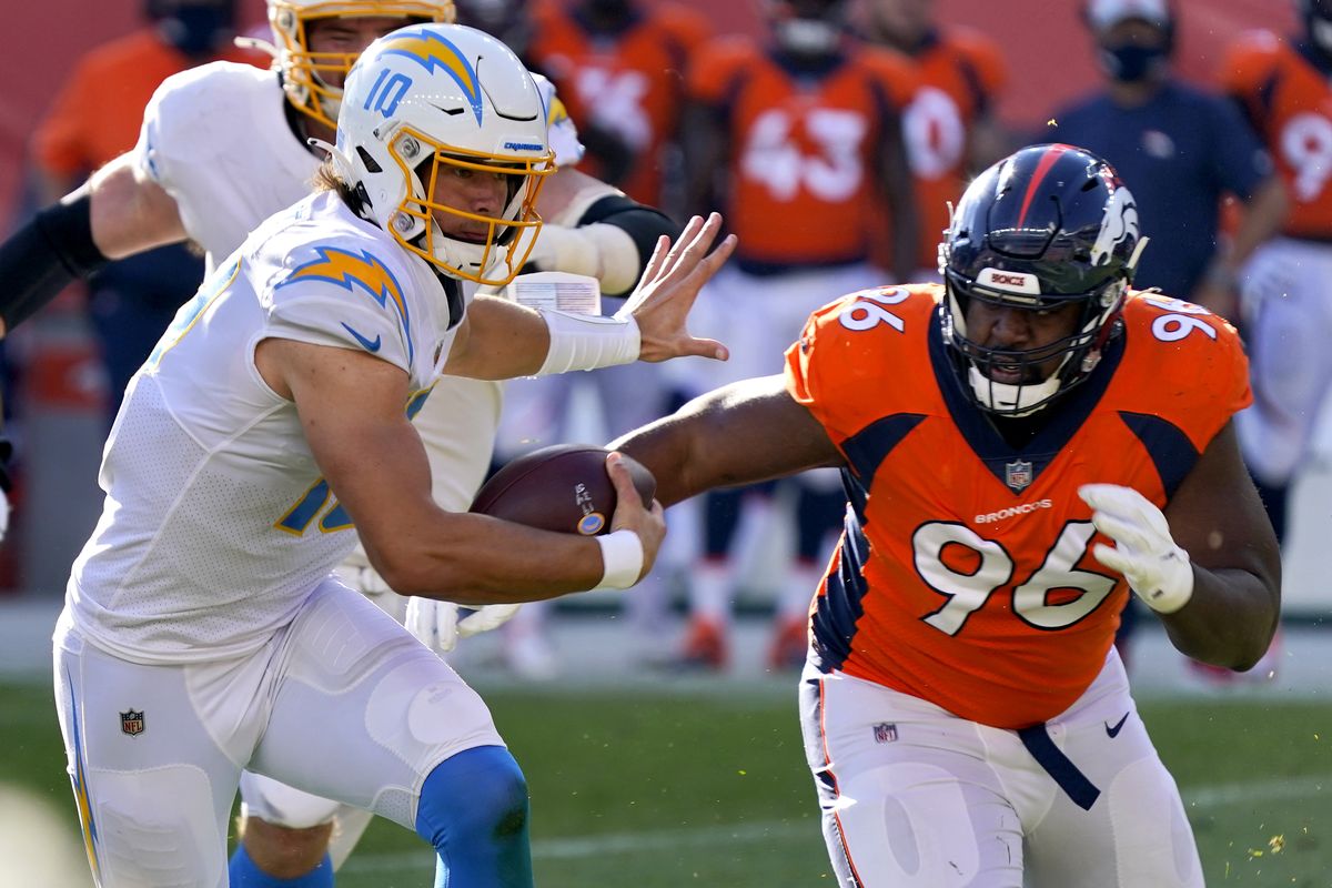 Los Angeles Chargers quarterback Justin Herbert (10) runs as Denver Broncos defensive end Shelby Harris (96) pursues during the first half of an NFL football game, Sunday, Nov. 1, 2020, in Denver.  (Associated Press)
