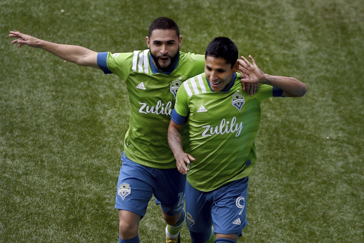 Seattle Sounders forward Raul Ruidiaz, right, celebrates with midfielder Alex Roldan, left, after scoring during second half of an MLS soccer match against the Portland Timbers in Portland, Ore., Sunday, May 9, 2021.  (Steve Dykes)