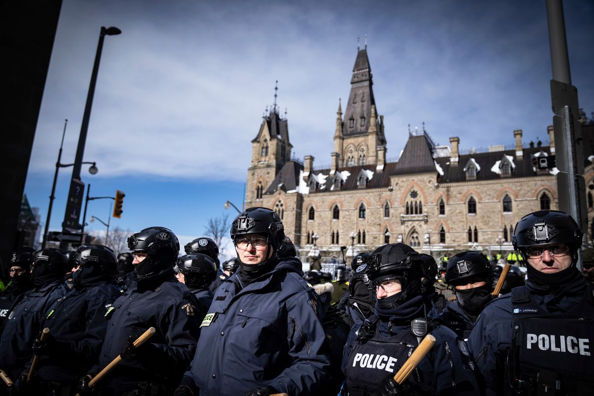 Police block protesters Saturday after taking the main street where trucks are parked in Ottawa near Parliament Hill. (Robert Bumsted)