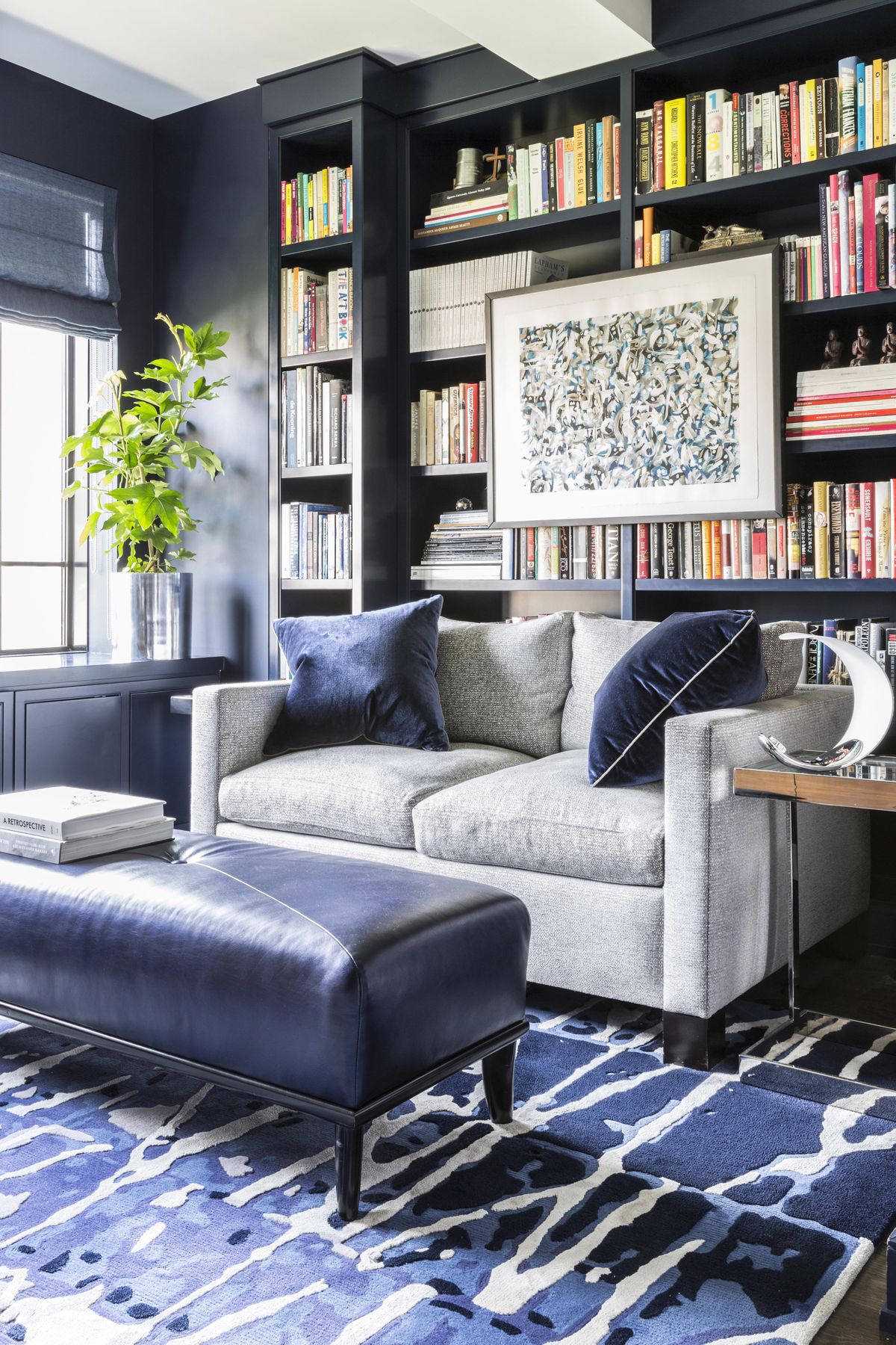 Designer Jamie Drake says “This cozy library with dramatic navy walls is energized in a distinct and artful way by the dynamic carpet underneath it also perfectly pulls together the room’s details.” (Marco Ricca / Drake/Anderson)