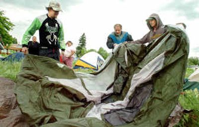 
Eric Hammond, right, helps other campers set up a tent in the vacant lot across the street from the East Central Community Center on Monday. A small tent city with about 14 people developed in the afternoon. 
 (Joe Barrentine / The Spokesman-Review)