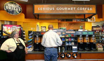 Mobil On the Run brew master Julie Gagne, at left, stands by as a customer makes his coffee selection at the gourmet coffe island at a Manchester, N.H., Mobil station.
(Associated Press / The Spokesman-Review)