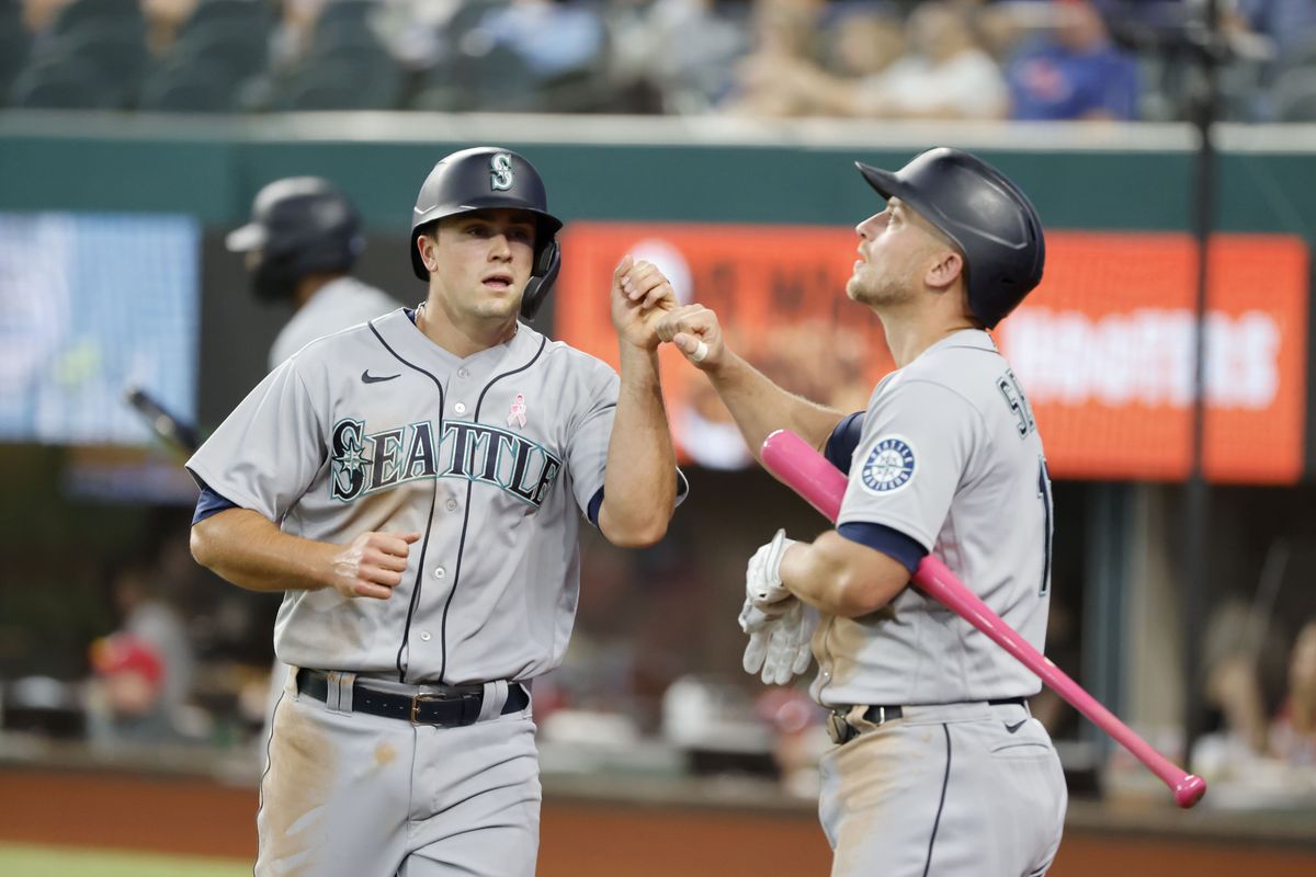 Seattle Mariners Evan White, left, is congratulated by Kyle Seager, right, after scoring a run against the Texas Rangers during the fifth inning of a baseball game Sunday, May 9, 2021, in Arlington, Texas.  (Michael Ainsworth)