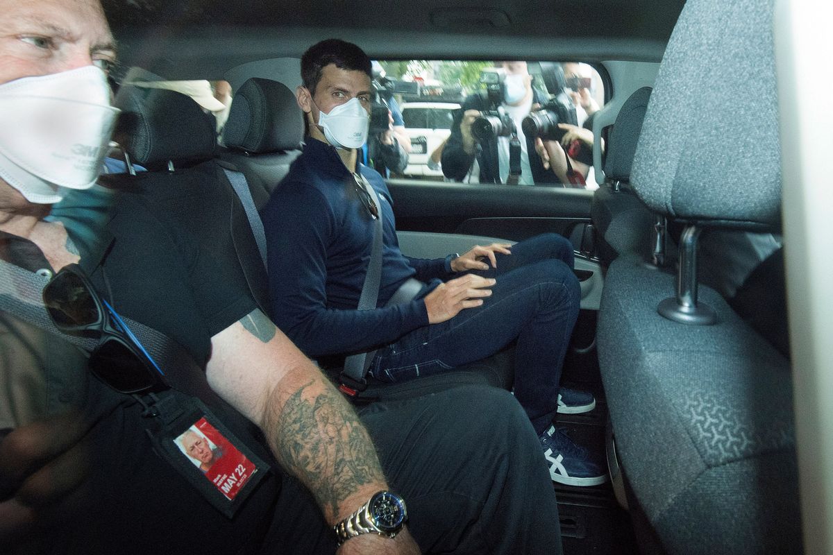 Serbian tennis player Novak Djokovic, center, rides in car as he leaves a government detention facility before attending a court hearing at his lawyers office in Melbourne, Australia, Sunday, Jan. 16, 2022. A federal court hearing has been scheduled for Sunday, a day before the men
