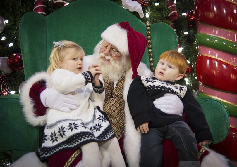 After they had their picture taken, twins, Maddie and Erik Cathcart, 2, tell Santa what they want for Christmas at River Park Square on Saturday. (Colin Mulvany)