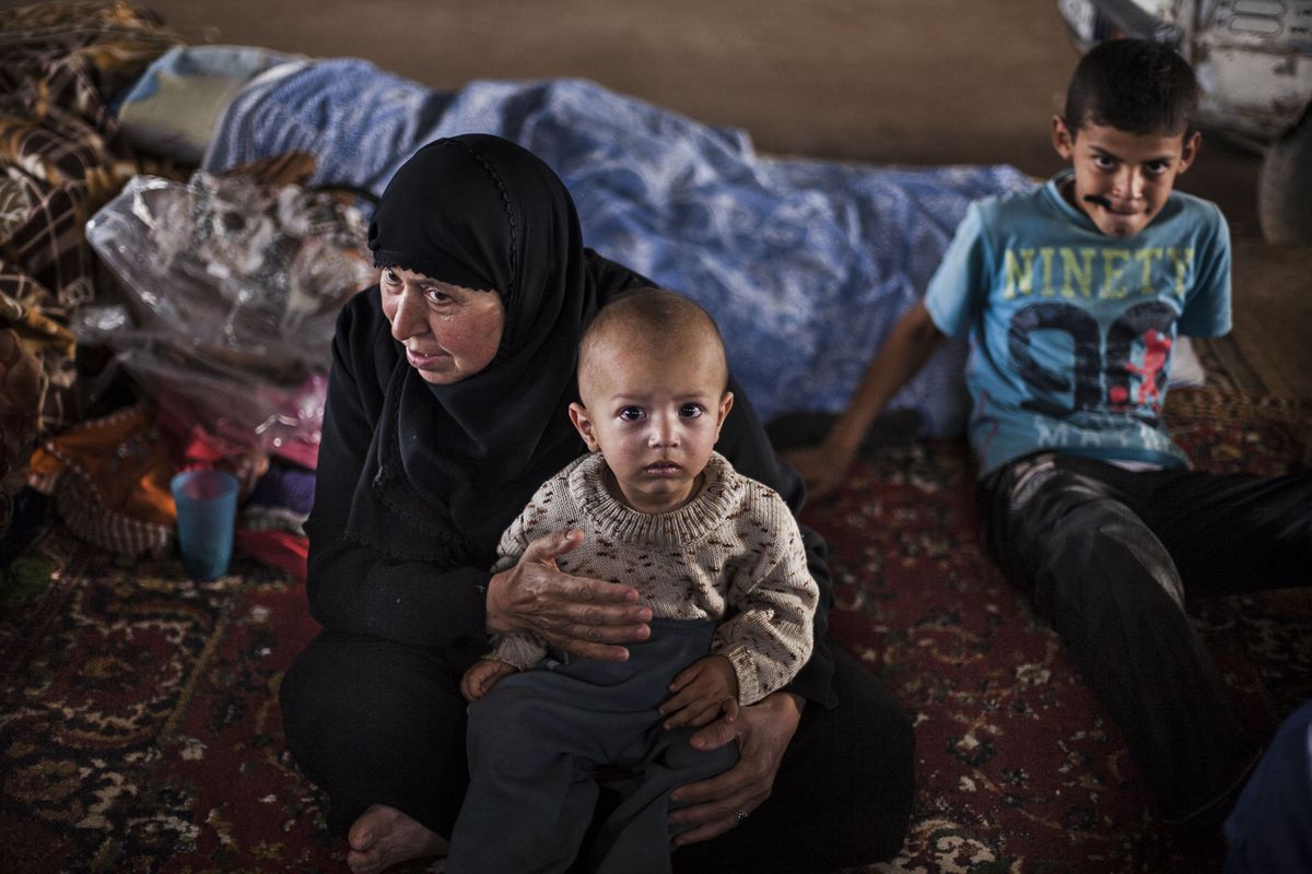 A displaced Syrian woman and her grandson sit in a refugee camp on the border with Turkey, near Azaz village, Syria. Up to 3,000 Syrians are leaving the country every day, said Vincent Cochetel of the U.N. refugee agency. (Associated Press)