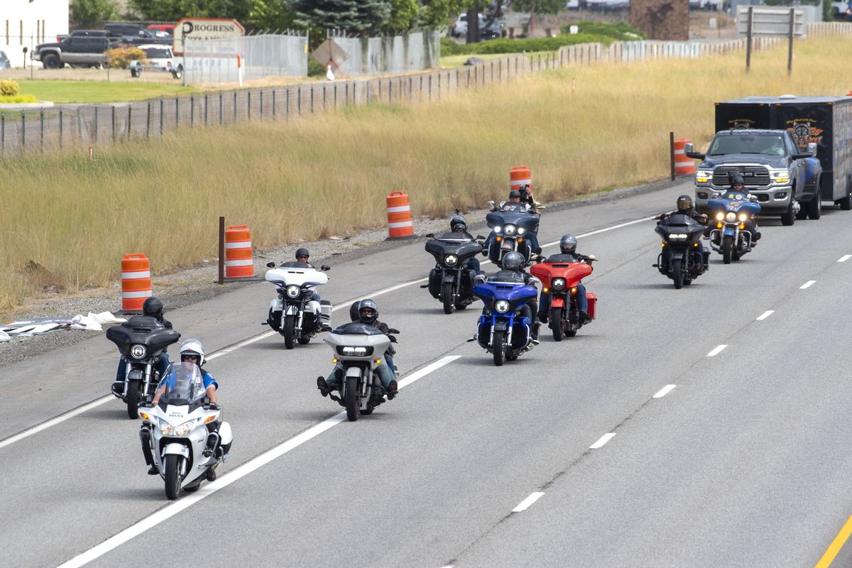 A group of motorcyclists follow a police officer down I-90 to the Barker Road exit, Thursday, Aug. 6, 2020, in Spokane Valley. The group was part of the End of Watch Ride to Remember event that arrived at Lone Wolf Harley Davidson Thursday.  (Jesse Tinsley/The Spokesman-Review)