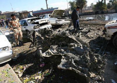 
Iraqis walk past the scene of a car bombing Thursday in Baghdad. Also that day, police said, 47 tortured bodies were found dumped across the city, up from 27 a day earlier. 
 (Associated Press / The Spokesman-Review)