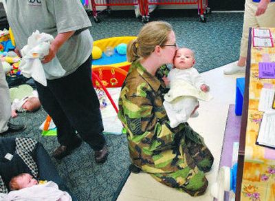 
Tech. Sgt. Julie Dumlao greets her 2-month-old baby, Lee, at the Child Development Center  at Fairchild Air Force Base.
 (Brian Plonka / The Spokesman-Review)