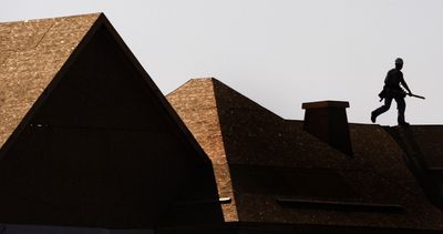 A construction worker walks along the roof line of a senior living community being built in Chagrin Falls, Ohio, on Friday.  (Associated Press / The Spokesman-Review)