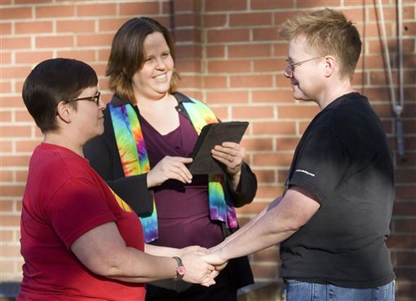 Tabitha Simmons, left, and Katherine Sprague, right, are married by Rev. Elizabeth Stevens, from the Unitarian Universalist Church of the Palouse, outside the Latah County Courthouse in Moscow, Idaho, on Friday, Oct. 10, 2014. Sprague and Simmons were the first couple to be issued a same-sex marriage license in Latah County.  (AP/Moscow-Pullman Daily News / Geoff Crimmins)