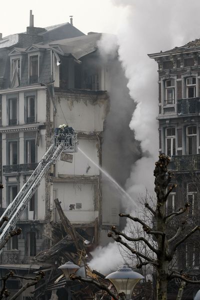 Firemen try to extinguish a fire in a collapsed building in Liege, Belgium, on Wednesday.  (Associated Press)