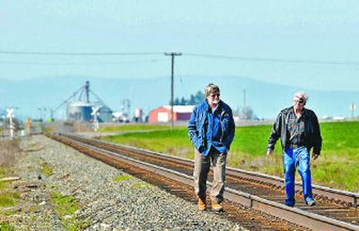 
John Beecher, left, and Don Hansen,  friends  of Steve Gaddum, walk the Rathdrum Prairie site Friday where Gaddum was killed when his car and a train collided on Thursday. 
 (Jesse Tinsley / The Spokesman-Review)