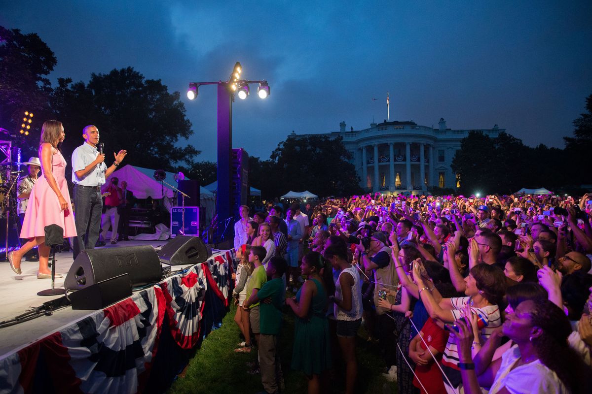 President Barack Obama, accompanied by first lady Michelle Obama, delivers remarks Saturday during an Independence Day celebration on the South Lawn of the White House in Washington. (Associated Press)