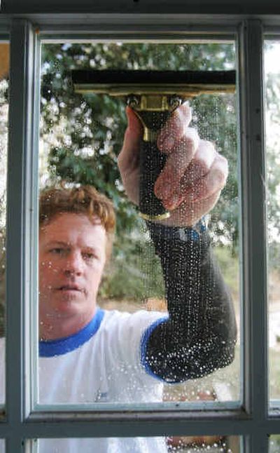 
 Sam Burkett, of Expert Windows of Fort Worth, Texas, uses a squeegee to wipe windows dry to prevent streaking after the windows have been washed, scraped and scrubbed. 
 (Knight Ridder / The Spokesman-Review)