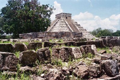 
A frieze of skulls adorns the side of the tzompantli, the platform probably used to exhibit sacrificed prisoners at Chichen Itza, with El Castillo in the background. 
 (Associated Press / The Spokesman-Review)