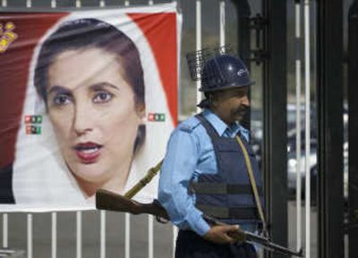 
A Pakistani police officer stands guard next to a portrait of slain opposition leader Benazir Bhutto outside the Parliament House in Islamabad on Monday. Associated Press
 (Associated Press / The Spokesman-Review)