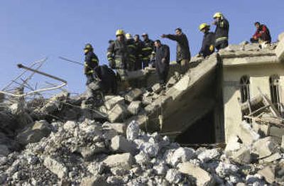 
Iraqi firefighters and residents of Mosul, Iraq, inspect the site Thursday where a huge explosion on Wednesday collapsed a three-story apartment building and ravaged adjacent houses. 
 (Associated Press / The Spokesman-Review)