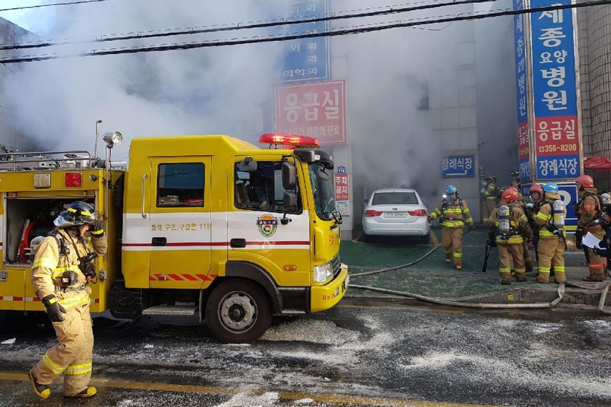 Firefighters work as smoke billows from a hospital in Miryang, South Korea, Friday, Jan. 26, 2018. The hospital fire causes scores of casualties and injuries, according to a fire agency official. (National Fire Agency / Yonhap)