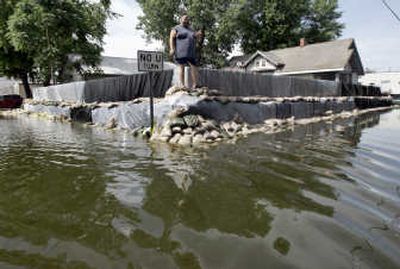 
Darin Davis stands atop a sandbag wall surrounding his house Thursday  in Louisiana, Mo. Associated Press
 (Associated Press / The Spokesman-Review)