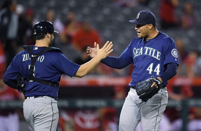 Seattle Mariners catcher Mike Zunino, left, and starting pitcher Taijuan Walker congratulate each other after Walker threw a three-hitter against the Los Angeles Angels in a baseball game Tuesday in Anaheim, Calif. The Mariners won 8-0. (Mark J. Terrill / AP)