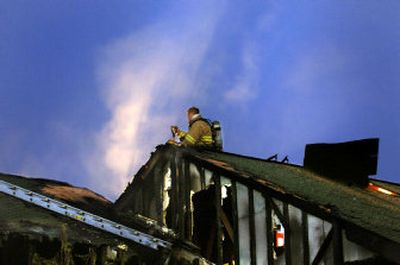 
Floodlights backlight steam and smoke coming from the roof of an  apartment Friday night at Cozza and Nevada. The blaze destroyed one unit and damaged others in a complex of four apartments at the Cedar Springs Apartments. 
 (Christopher Anderson/ / The Spokesman-Review)