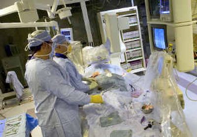 
At Deaconess Medical Center, cardiovascular technician Shawn Hickman left, and cardiologist Brad Batkoff, insert an aortic stent in a patient Thursday. Deaconess has again been named one of the 100 top cardiovascular hospitals in the country. 
 (Colin Mulvany / The Spokesman-Review)